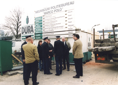503107 Afbeelding het bouwbord en de aanwezigen bij het slaan van de eerste paal voor het nieuwe politiebureau Marco ...
